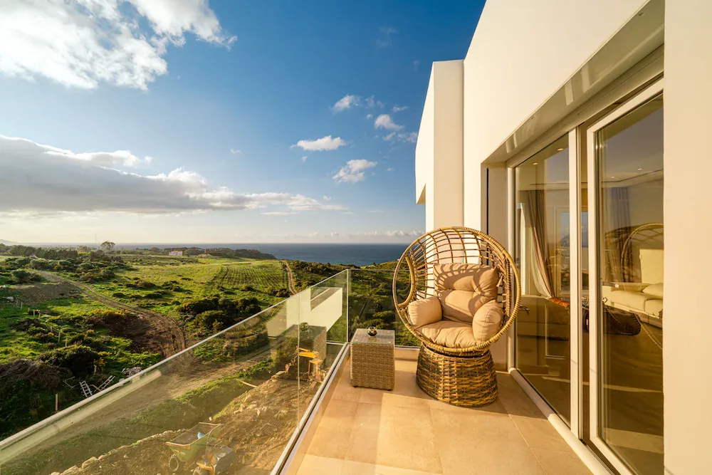 Terrasse avec fauteuil donnant sur un paysage côtier