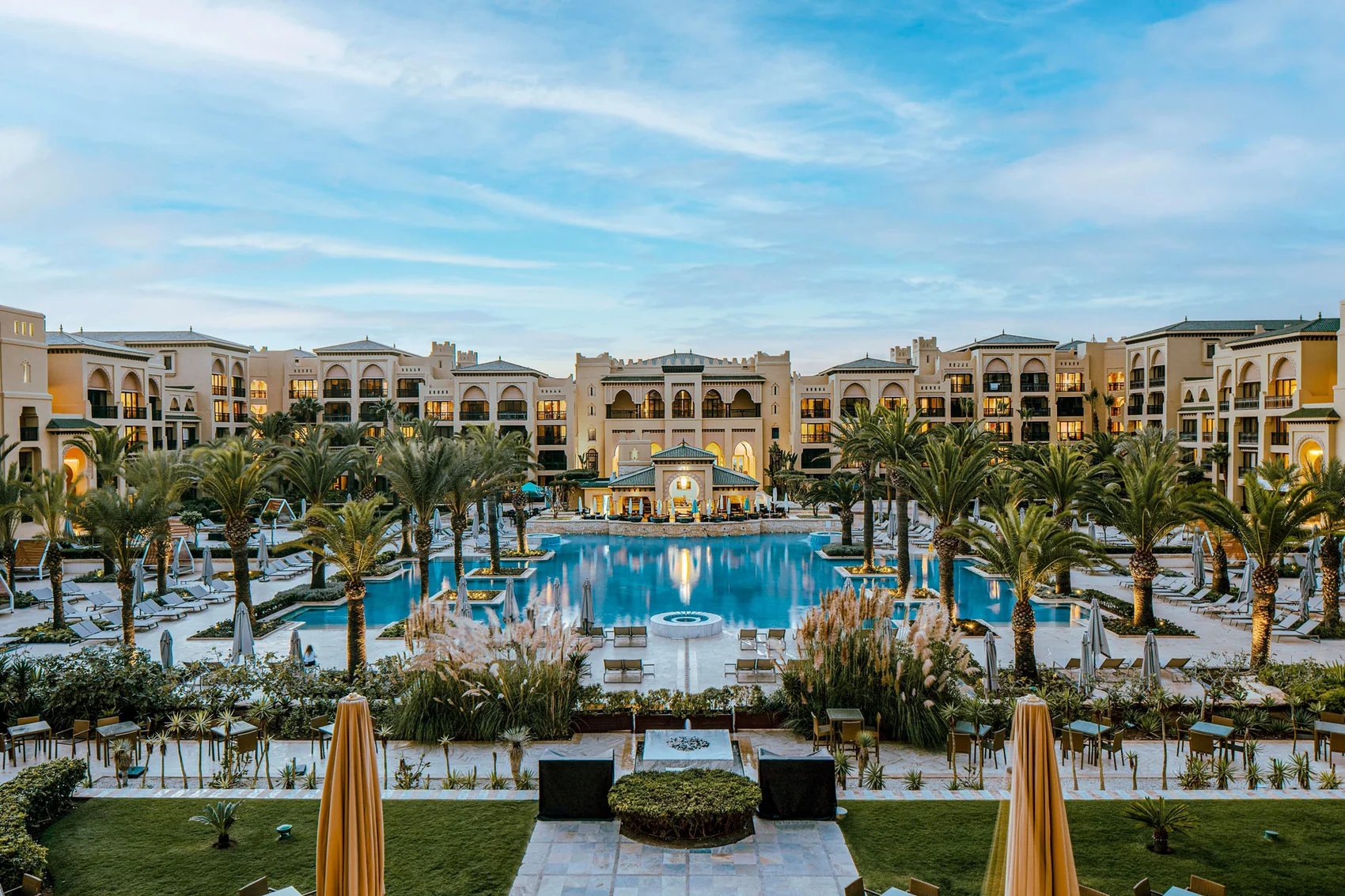 Grand resort avec piscine, palmiers et architecture élégante